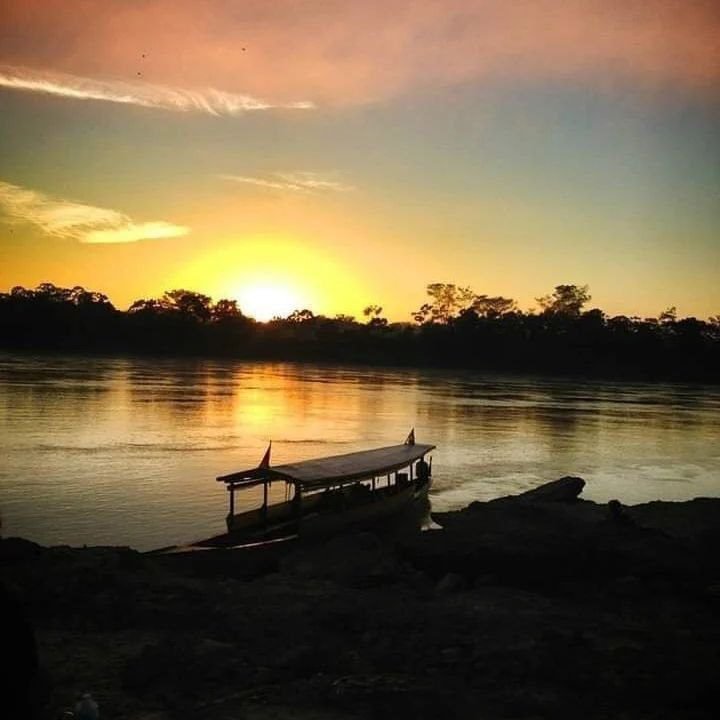 Vista del sunset en lancha en el rio por la Amazonía